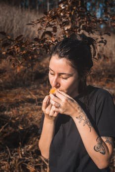 A woman eating mindfully outdoors, savoring her meal while surrounded by nature, fully present in the peaceful setting