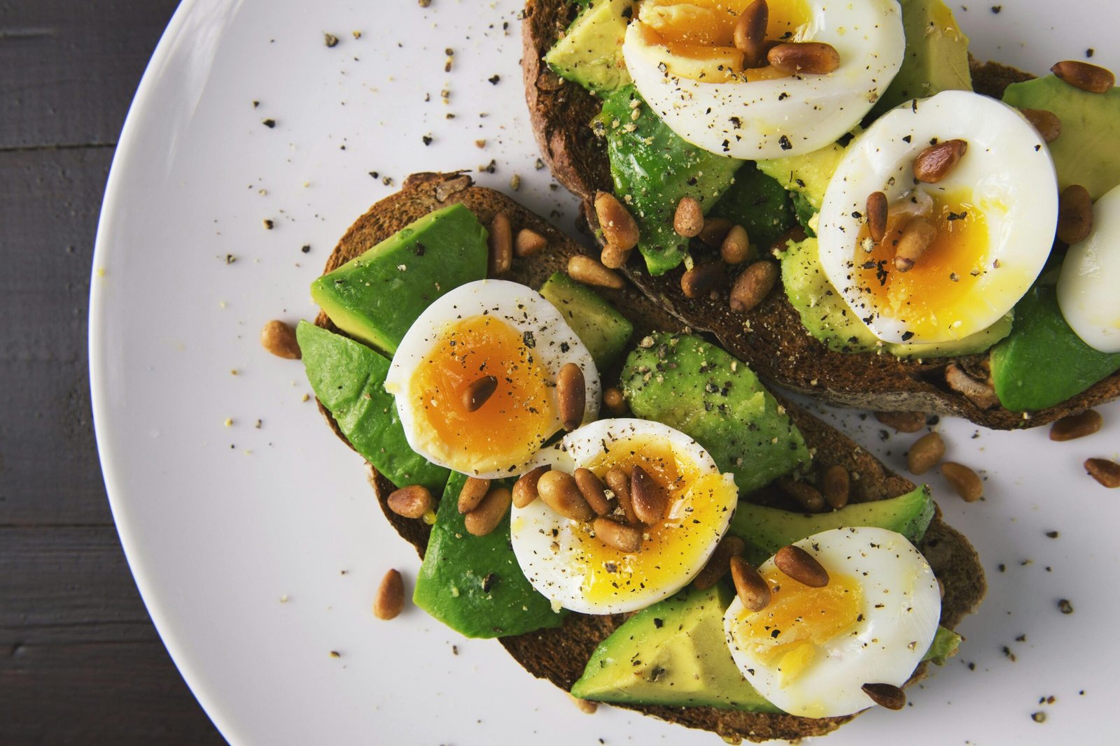 Plate with eggs, avocado, and nuts on toast, illustrating balanced macronutrients.