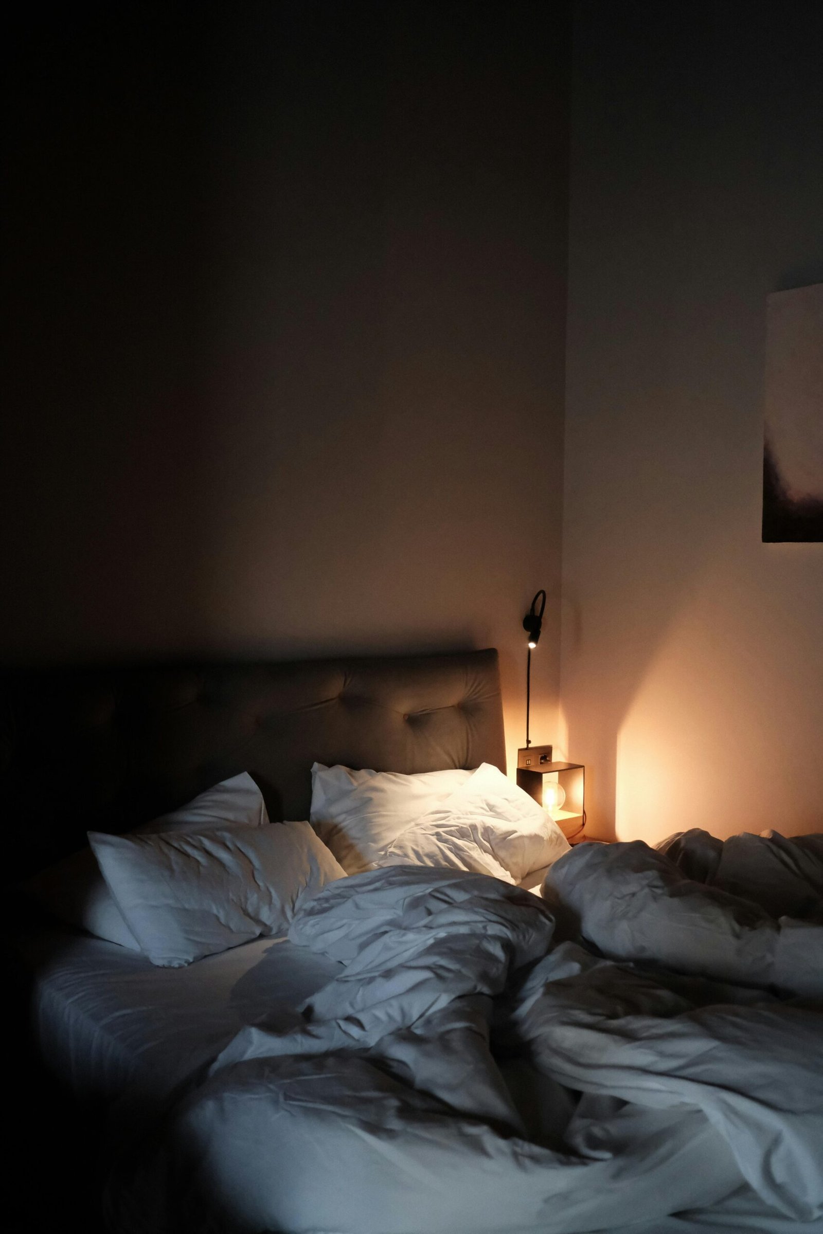 Bed with soft pillows and warm lighting in a cozy room.