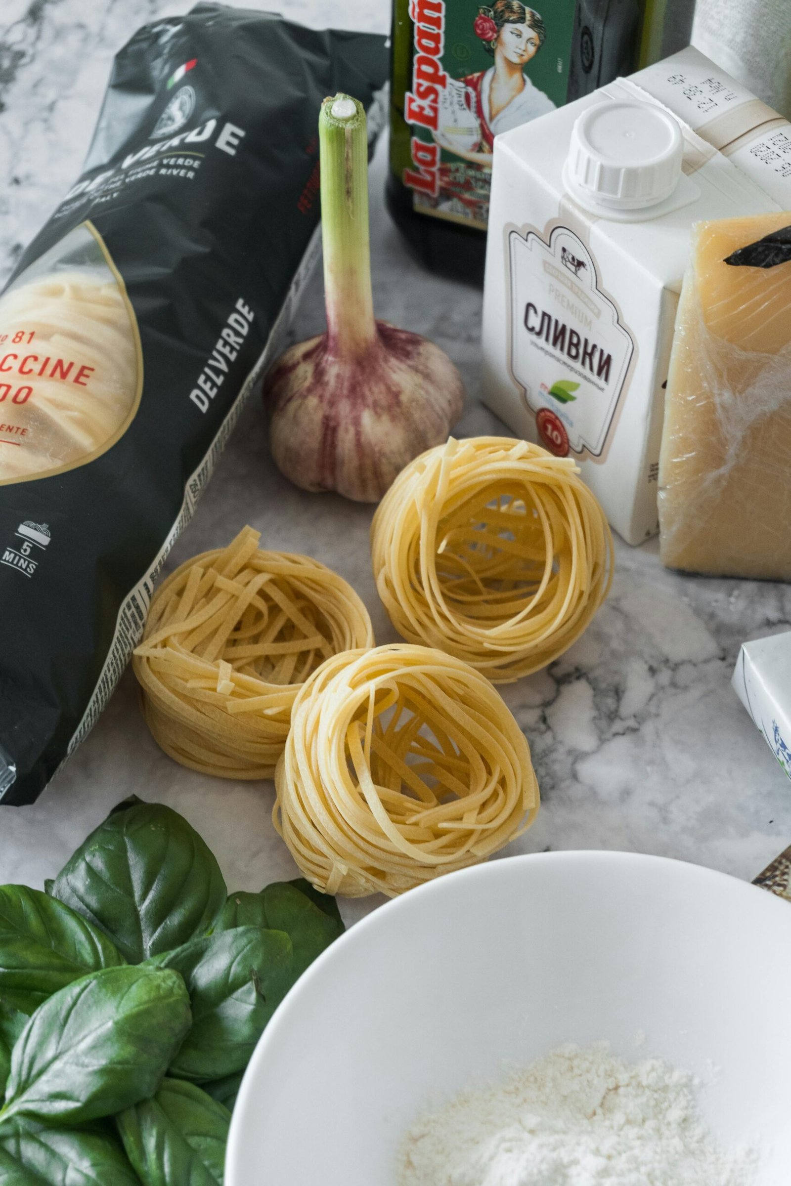 Ingredients for creamy garlic chicken tenderloin pasta laid out on a kitchen counter.