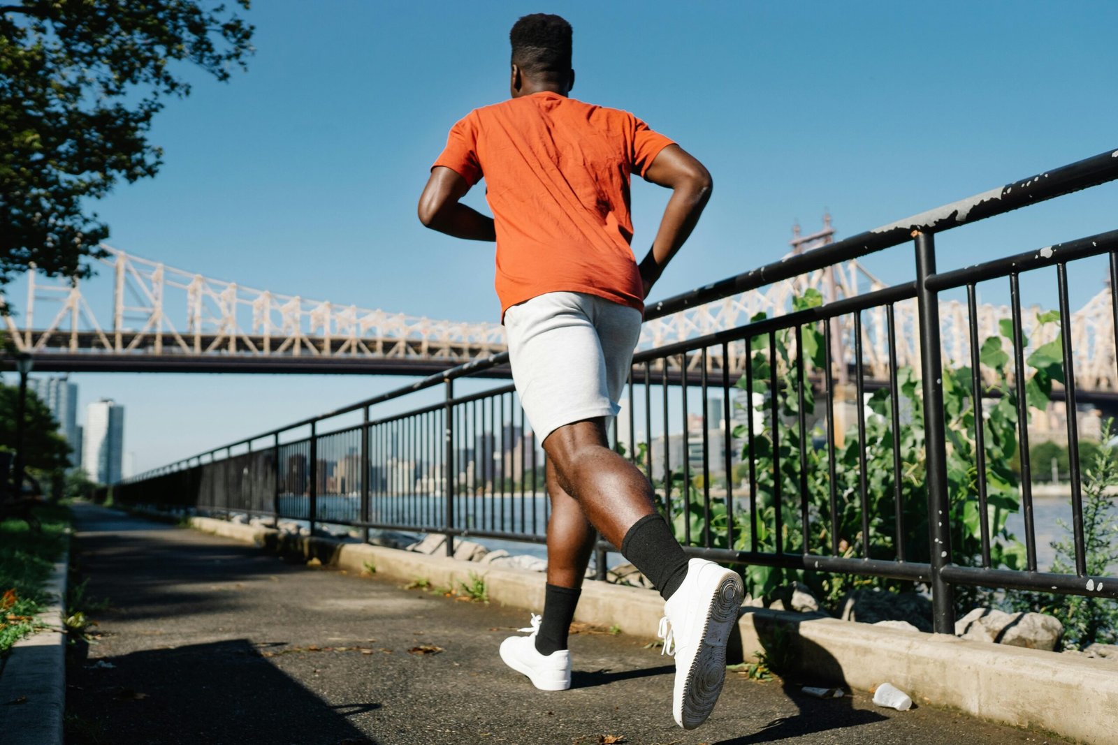 Person jogging at the park to manage stress and process emotions.