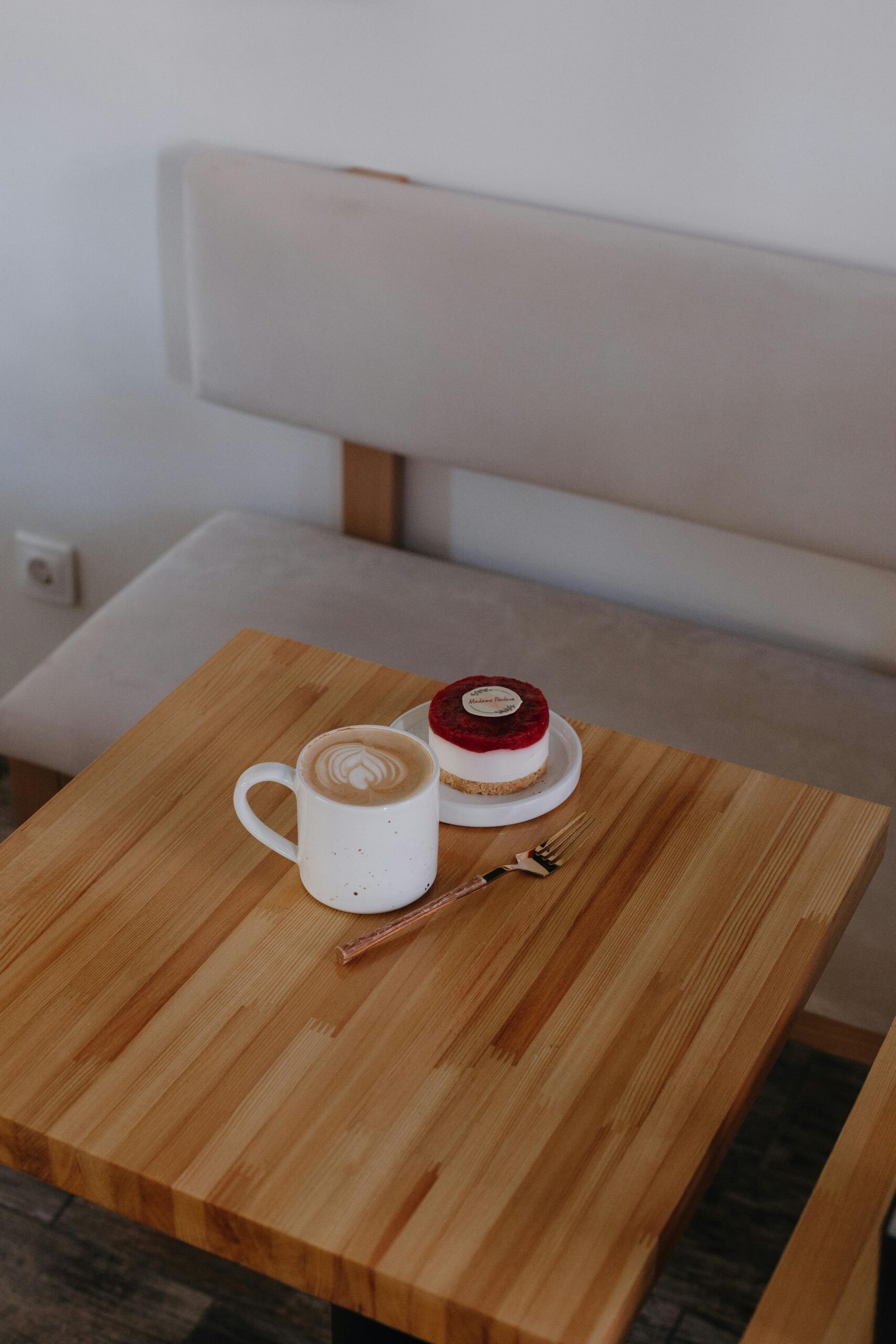 Coffee and red velvet cake on a wooden table, representing a rewarding treat for small study achievements in a cozy cafe setting.