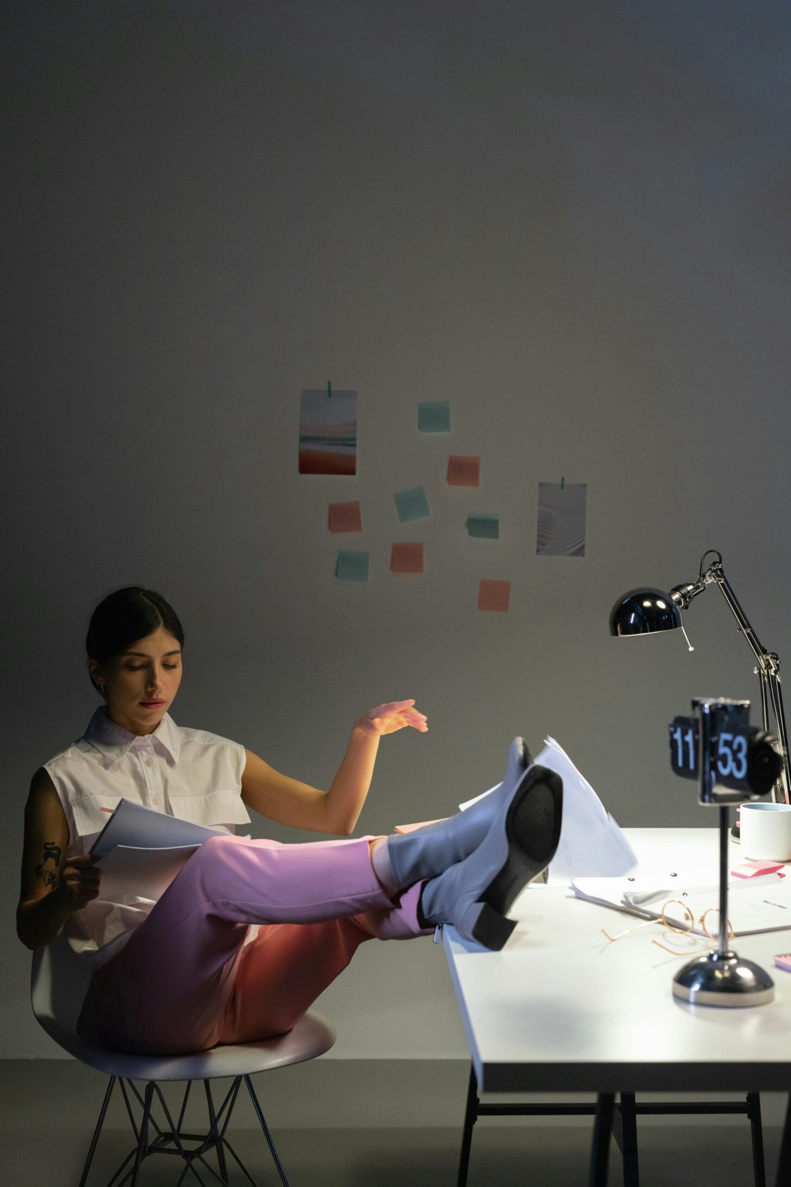 Person studying with an alarm clock nearby.